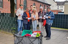Caritas und Ehrenamtliche der Gemeinde St. Laurentius präsentieren die Einladungen zum neuen Begegnungscafè