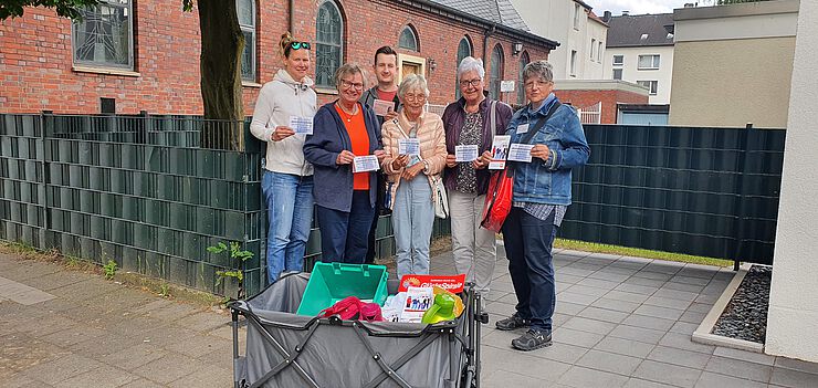 Caritas und Ehrenamtliche der Gemeinde St. Laurentius präsentieren die Einladungen zum neuen Begegnungscafè