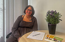 Eine Frau sitzt an einem Tisch.