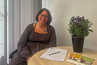 Eine Frau sitzt an einem Tisch.