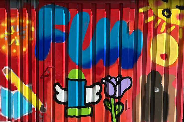 Auf einer Wand sind bunte Graffitis.