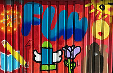 Auf einer Wand sind bunte Graffitis.