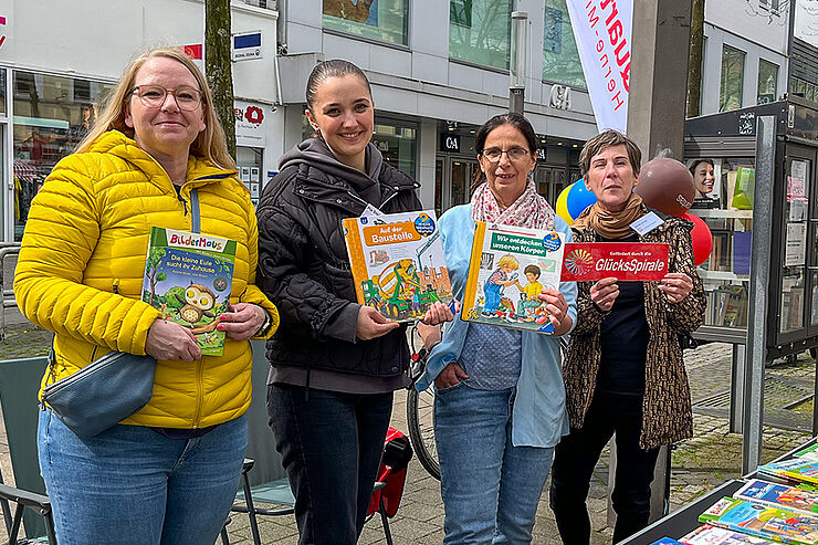 Caritas-Orga-Team zeigt bunte Kinderbücher.