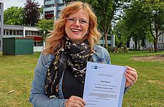 Eine Frau zeigt ein Zeugnis.