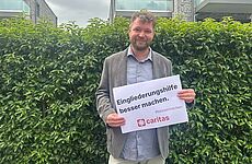 Ein Mann hält ein Schild mit der Aufschrift #bessermachen in der Hand.