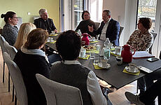 Mehrere Personen sitzen um einen Tisch herum.