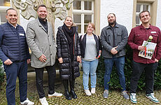 Vier Männer und zwei Frauen stehen nebeneinander.