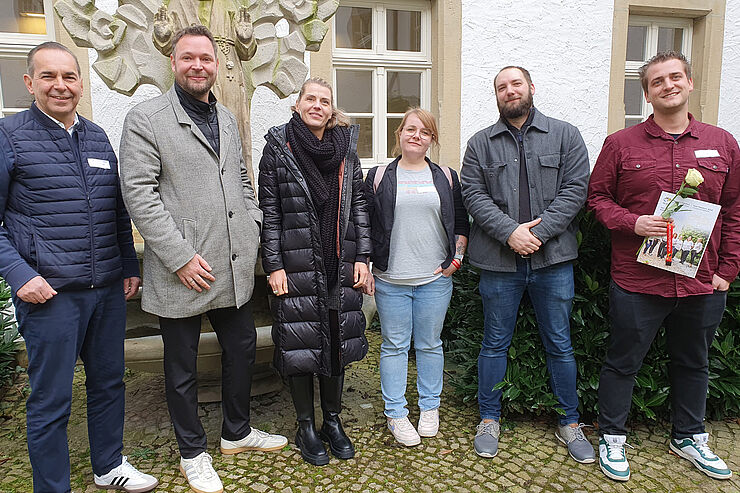 Vier Männer und zwei Frauen stehen nebeneinander.