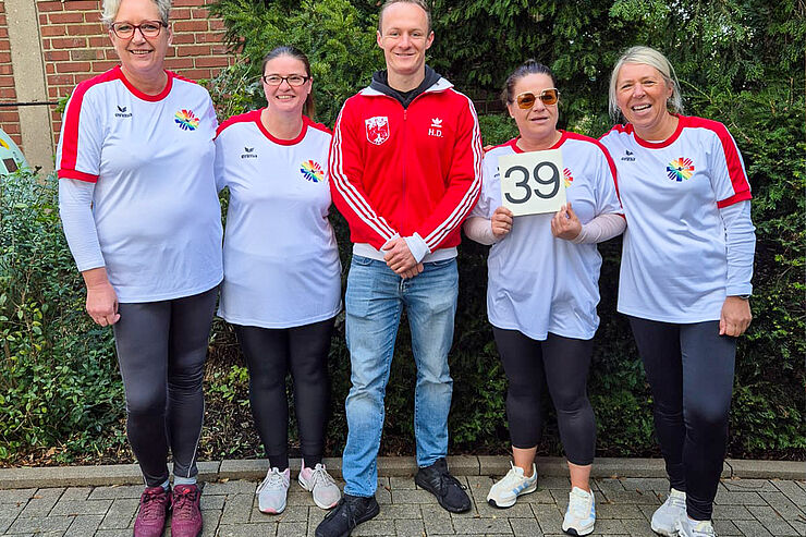 Vier Frauen in weißen Trikots stehen nebeneinander.