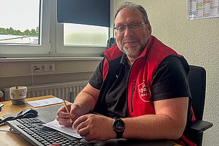 Ein Mann sitzt am Schreibtisch.