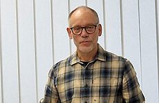 Ein Mann mit Brille schaut in die Kamera.