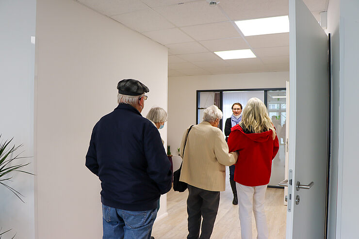 Agnes Michel, Leiterin der Caritas-Tagespflege, zeigt Besucher:innen die Räumlichkeiten.