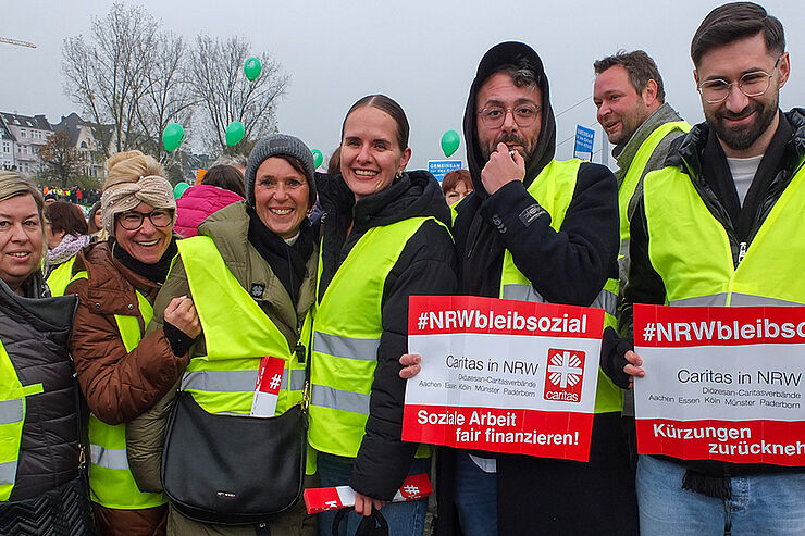 Sieben Menschen in gelben Warnwesten stehen zusammen.