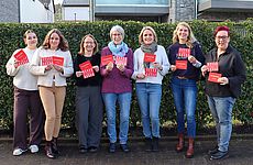 Sieben Frauen stehen nebeneinander.