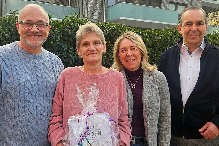 Vier Menschen stehen nebeneinander.