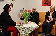 Drei Frauen sitzen zusammen.