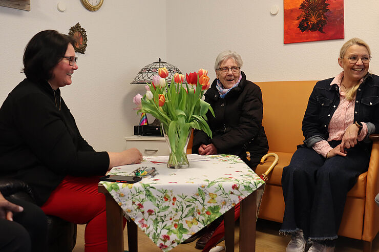 Drei Frauen sitzen zusammen.