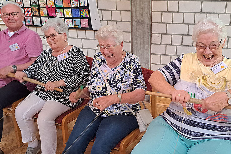 4 Menschen lachen in die Kamera.