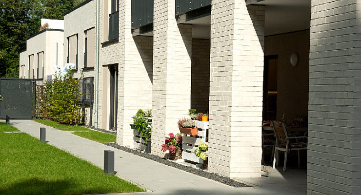 Rückseite des Albert-Schweitzer-Hauses mit einem Stück Rasenfläche und Terrasse