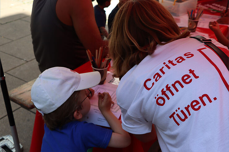 Ein T-Shirt mit der Aufschrift "Caritas öffnet Türen" ist von hinten zu sehen.